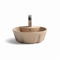 Round beige ceramic sink with modern faucet for bathroom or kitchen installation